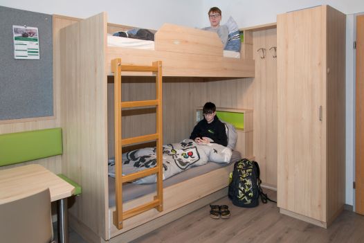 2 Schüler liegen im Bett (Stockbett) im Internatszimmer