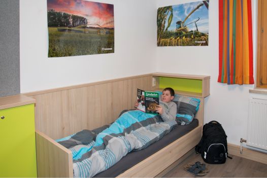 Ein Schüler liegt im Bett im Internatszimmer